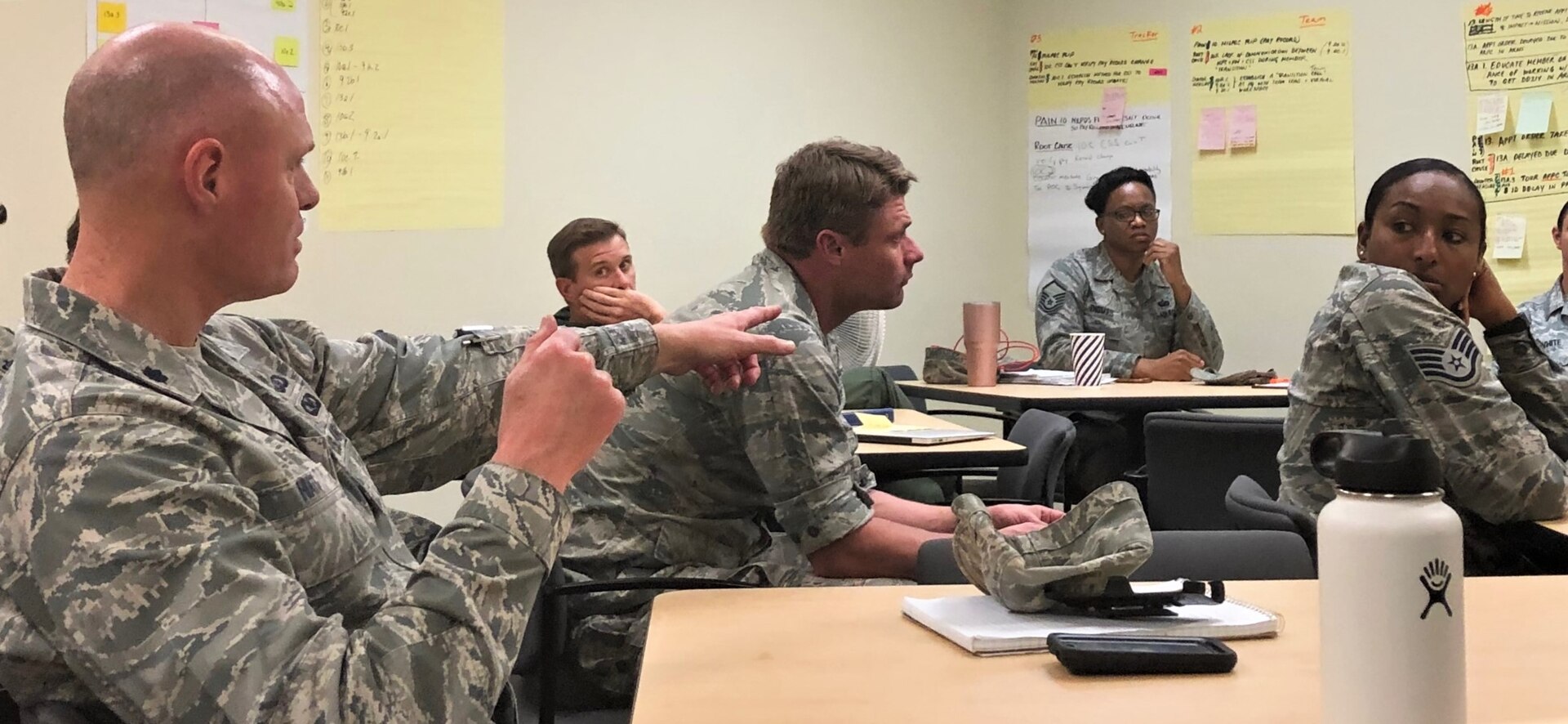 Lt. Col. Mark Hiatt, 340th Flying Training Group manpower and personnel director (left), discusses counter measures with group members at the Nov. 19-21 continuous process improvement event held at Joint Base San Antonio-Randolph, Texas, to address pay issues that occur when Reserve members transition between pay statuses. (U.S. Air Force photo by Janis El Shabazz)