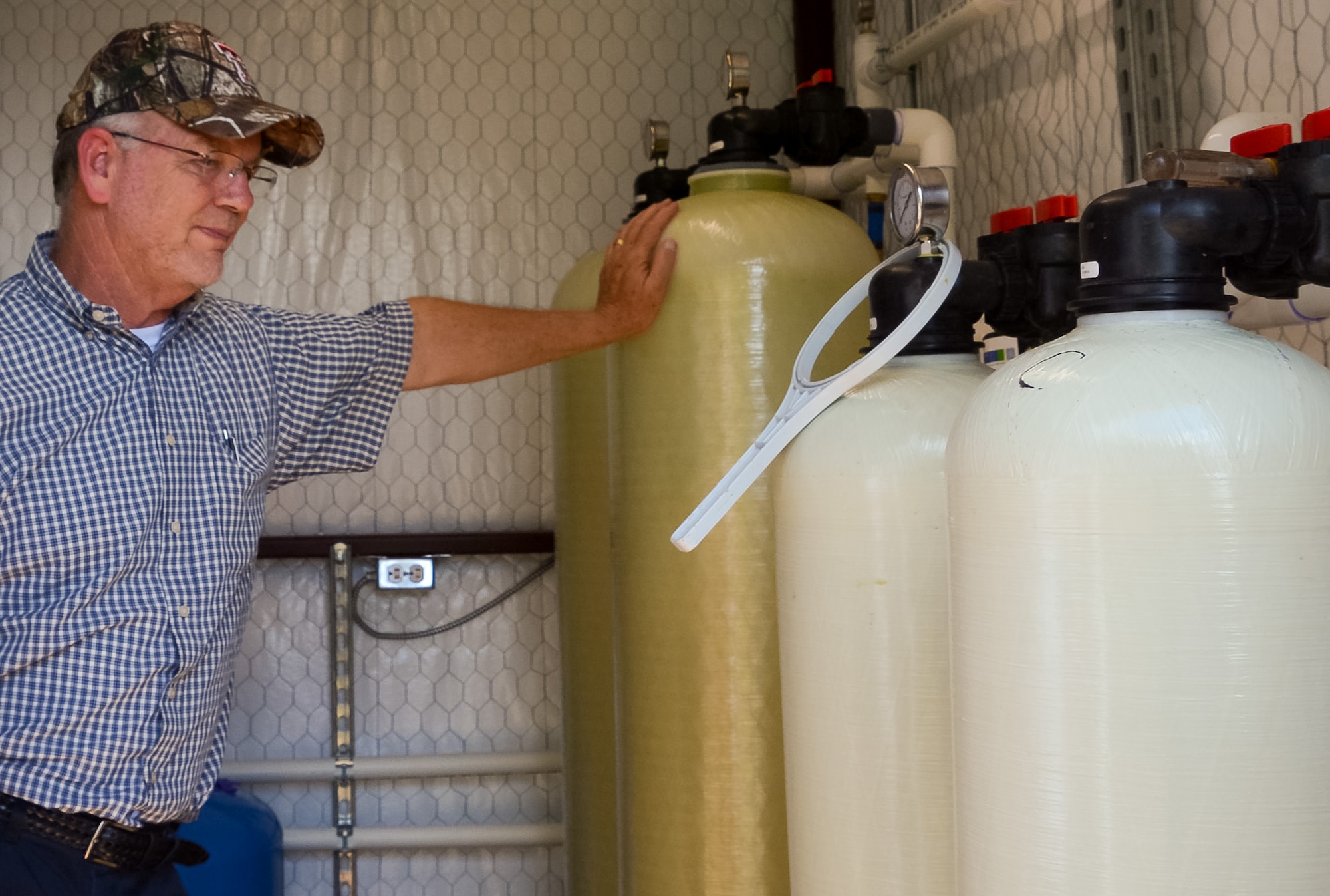 Paul Carroll, a program manager at the Air Force BRAC program, inspects a whole-house treatment system installed at a home near the former Reese Air Force Base in Lubbock, Texas, Aug. 22, 2018. The system is designed to remove PFAS from the home owners drinking water well. (U.S. Air Force courtesy photo)
