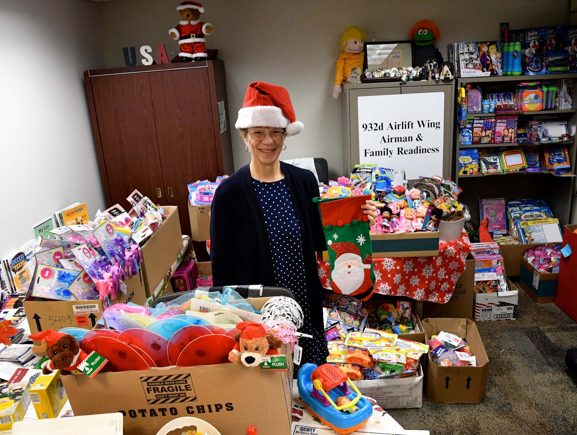 We are thankful this time of year for volunteers.  Various donated toy and food items for the upcoming holidays are ready to be distributed through the 932nd Airlift Wing Family Readiness Office, led by Deb Teague, standing at center. She and unit volunteers offloaded donations on behalf of the Air Force Reserve Command's Illinois unit located at Scott Air Force Base, Ill. The toys and food will be given out to reservists in Illinois during the final unit training assembly (UTA) December 7-8. The next upcoming activity is a job fair on January 11.  (U.S. Air Force photo by Lt. Col. Stan Paregien)