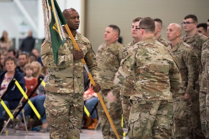 1st Sgt. Dennis Gregory assumes responsibility for the 157th Military Police Company by accepting the unit guidon during a deployment ceremony held Dec. 3, 2019, at the 167th Airlift Wing in Martinsburg, W.Va. More than 160 Soldiers will be deploying to Guantanamo Bay for nearly a year to support U.S. Southern Command’s high-risk detention operations. (U.S. Air National Guard photo by Senior Master Sgt. Emily Beightol-Deyerle)