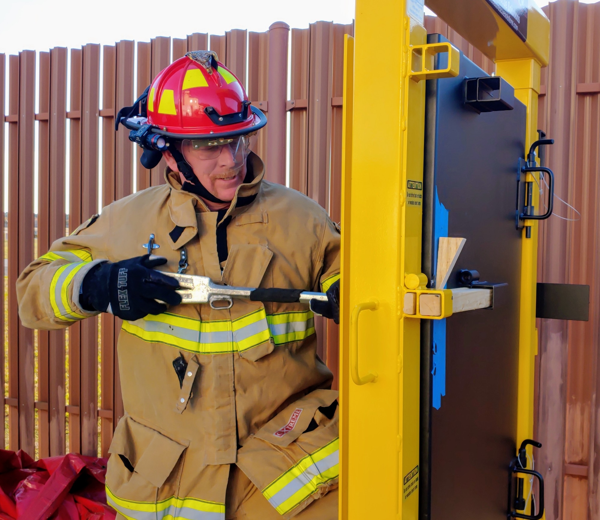 Photo shows firefighter using door simulator to practice forcible entry.
