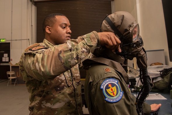 Tech. Sgt. Damron Crump, 100th Operations Support Squadron aircrew flight equipment craftsman, fits Maj. Joe Schmitt, 351st Air Refueling Squadron pilot, for chemical gear at RAF Mildenhall, England, Dec. 3, 2019. Aircrew members receive a set of chemical protection gear to wear on missions in environments vulnerable to chemical attack. (U.S. Air Force photo by Airman 1st Class Joseph Barron)