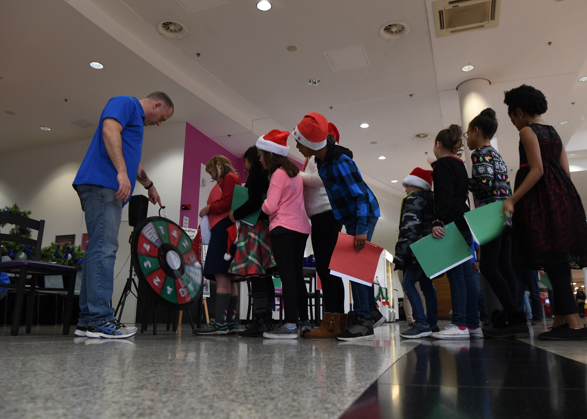 Children line up to spin the prize wheel during the Angel Tree Kickoff at Ramstein Air Base, Germany, Dec. 1, 2019. The event was held at the Kaiserslautern Military Community Center and
promoted the Angel Tree Program, a charity that financially helps military families in the community. (U.S. Air Force photo by Staff Sgt. Kirby Turbak)