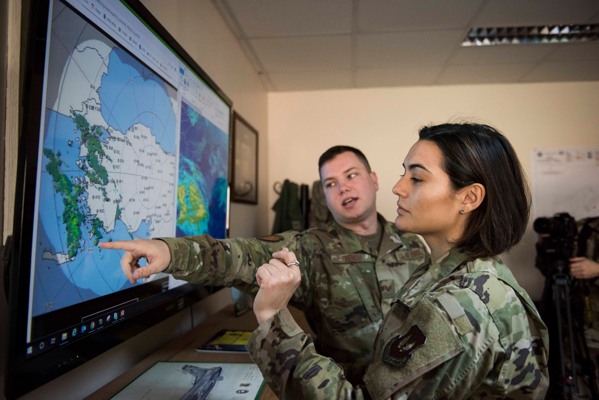 U.S. Air Force Staff Sgt. Sean French, 39th Operations Support Squadron weather forecaster, discusses weather activity with U.S. Air Force Capt. Jackie Kell, 39th OSS intelligence flight commander, Nov. 25, 2019, at Incirlik Air Base, Turkey. Critical to a successful operation, weather and intelligence constitute a major component of military planning. (U.S. Air Force photo by Staff Sgt. Joshua Magbanua)
