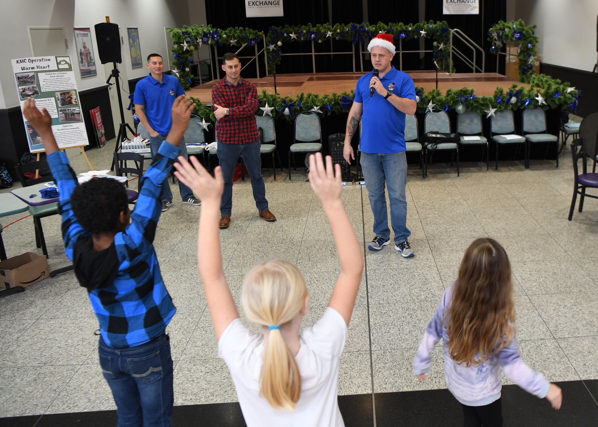 U.S. Air Force Master Sgt. Daniel Schumann, 86th Maintenance Group first sergeant, plays “Santa says” with children during the Angel Tree Kickoff at Ramstein Air Base, Germany, Dec. 1, 2019. Angel Tree donation spots can be found at a variety of high-traffic areas around the Kaiserslautern Military Community. (U.S. Air Force photo by Staff Sgt. Kirby Turbak)