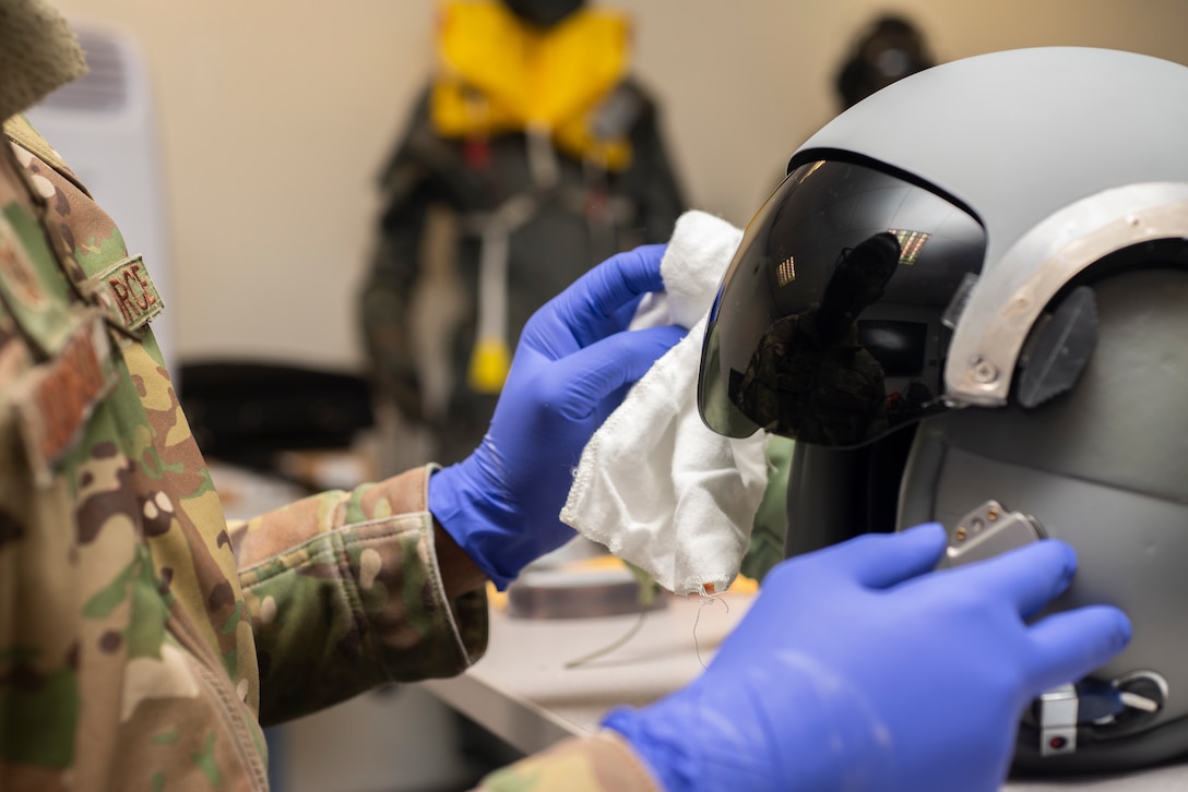 Tech. Sgt. Alexander Johnston, 100th Operations Support Squadron aircrew flight equipment lead trainer, cleans a helmet visor at RAF Mildenhall, England, Dec. 3, 2019. The AFE shop maintains and inspects equipment such as flight helmets, oxygen masks, survival gear and radios that help pilots and other aircrew complete the mission. (U.S. Air Force photo by Airman 1st Class Joseph Barron)