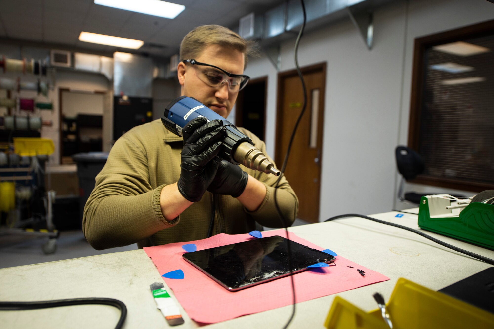 A photo of an Airman turning on heating equipment for electronics repair