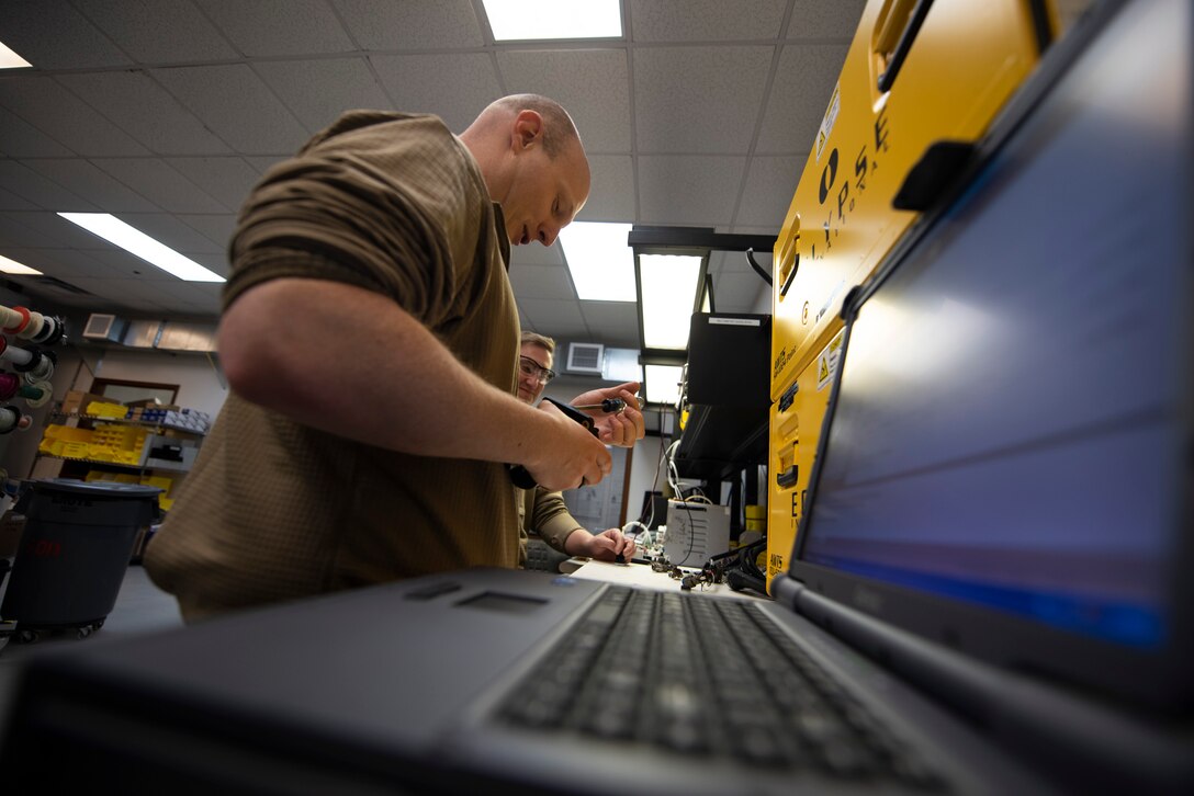 A photo of an Airman repairing an aircraft button