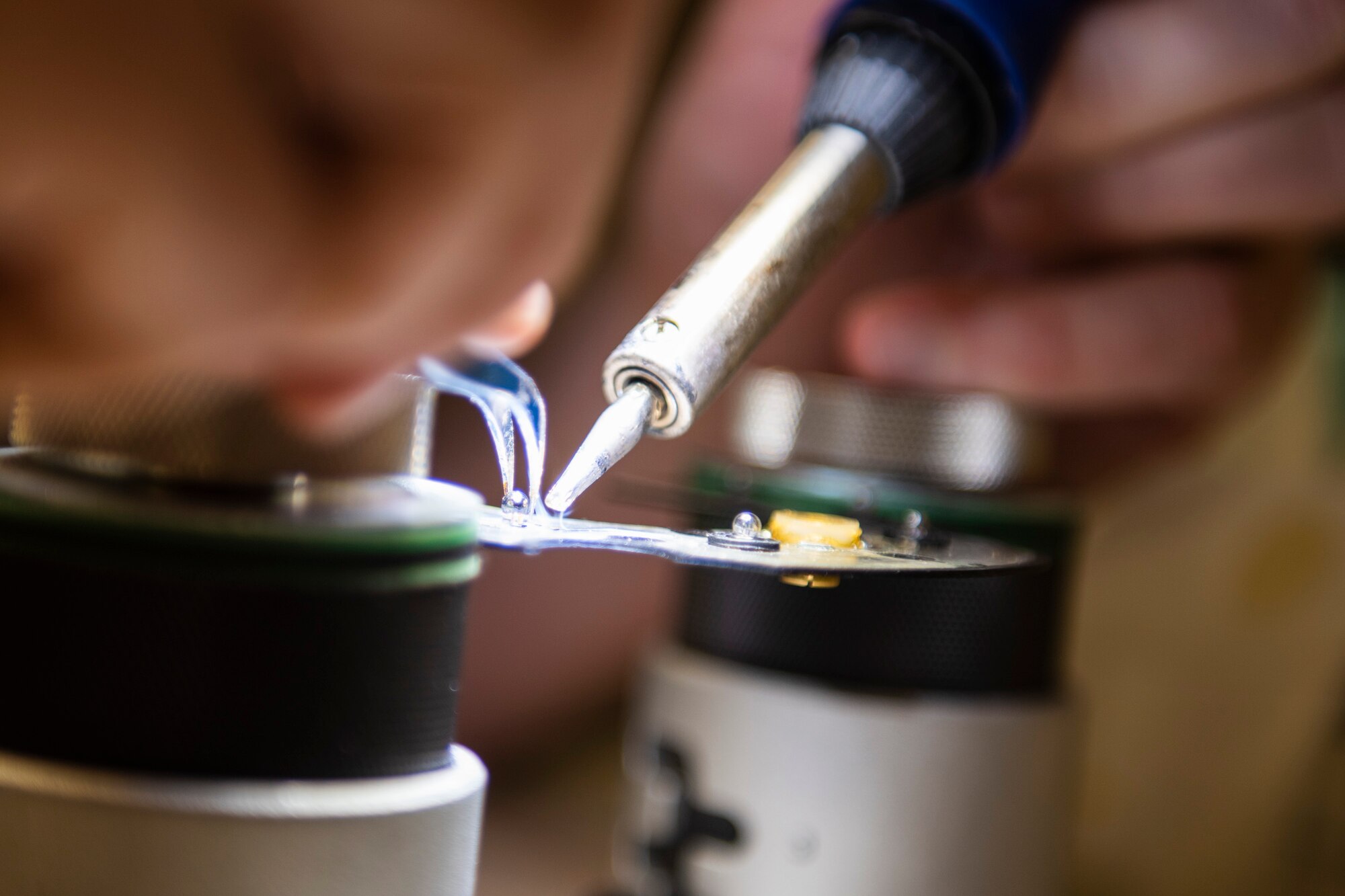 A photo of an Airman soldering an aircraft part