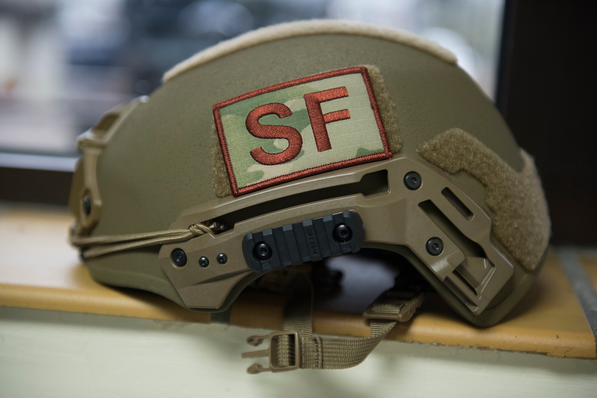A U.S. Air Force 422nd Security Forces Squadron ballistic helmet lays on the table during a recall exercise at RAF Croughton, England, November 21, 2019. U.S. Air Forces in Europe-Air Forces Africa provided 422nd SFS members with the latest helmet protection to improve hearing and communication with a specially-designed frame, lessen fatigue with a balanced and lighter helmet, and improve capability to hold night-vision goggles. (U.S. Air Force photo by Airman 1st Class Jennifer Zima)