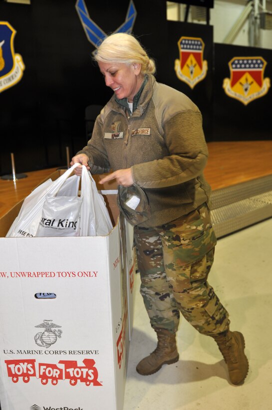 Master Sgt. Kathleen Wyatt, 445th Civil Engineer Squadron emergency management craftsman, donates a toy in support of Toys for Tots. The 445th Airlift Wing held a chili cook-off Dec. 2, 2019 to support this year’s Toys for Tots. Attendees were asked to donate a toy for a bowl of chili and dessert. (U.S. Air Force photo/Stacy Vaughn)