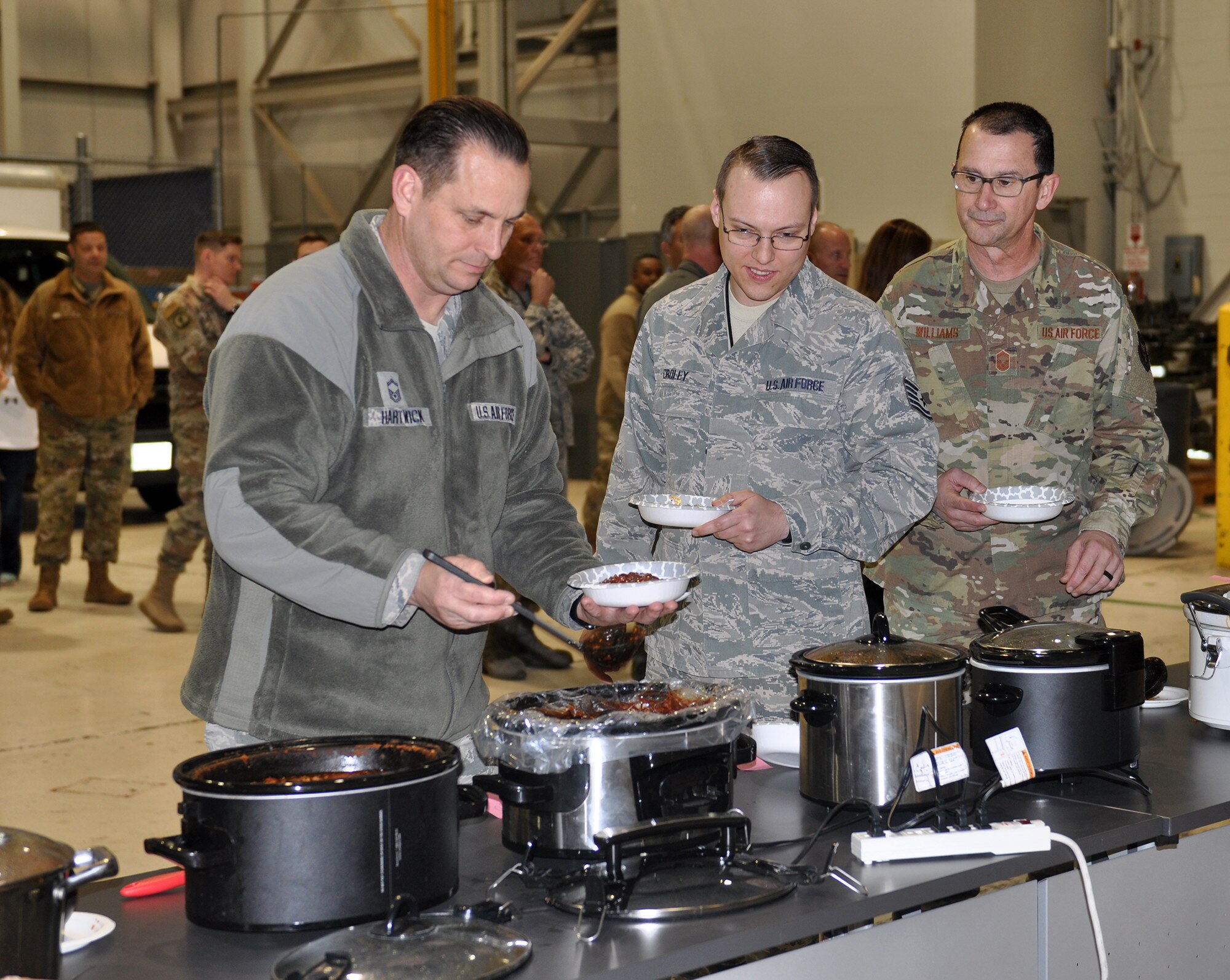 Members of the 445th Airlift Wing fill their bowls with chili during the 445th Airlift Wing’s chili cook-off Dec. 2, 2019.