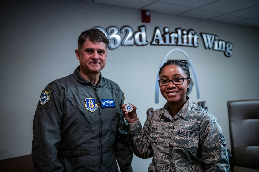 Tech. Sgt. Brandy Brown, religious affairs Airman, 932nd Airlift Wing Chaplain’s Office, displays the Wing coin Col. Glenn Collins, 932nd AW commander, presented Brown after having shared her Airman's Story with Wing leadership during the the Wing Review meeting, Nov. 15, 2019, Scott Air Force Base, Illinois.  Each month before the unit training assembly a Citizen Airman shares some facts about their Air Force career,  civilian life, and goals within the Air Force Reserve. (U.S. Air Force photo by Christopher Parr)