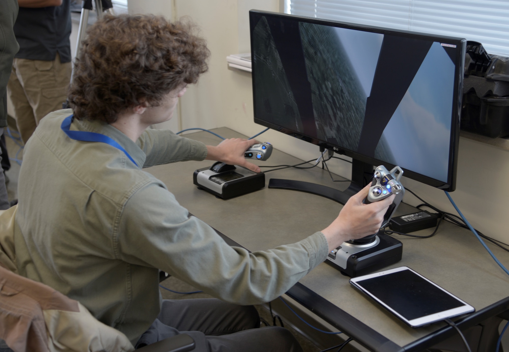Bob Theimer, Air Force Research Laboratory software engineer, pilots a virtual aircraft to begin a demonstration using live, virtual and constructive elements into one training environment.  During a training scenario, people are physically operating equipment in real time parallel to the identically matched scenario with a computer-generated environment. (U.S. Air Force photo/John VanWinkle)
