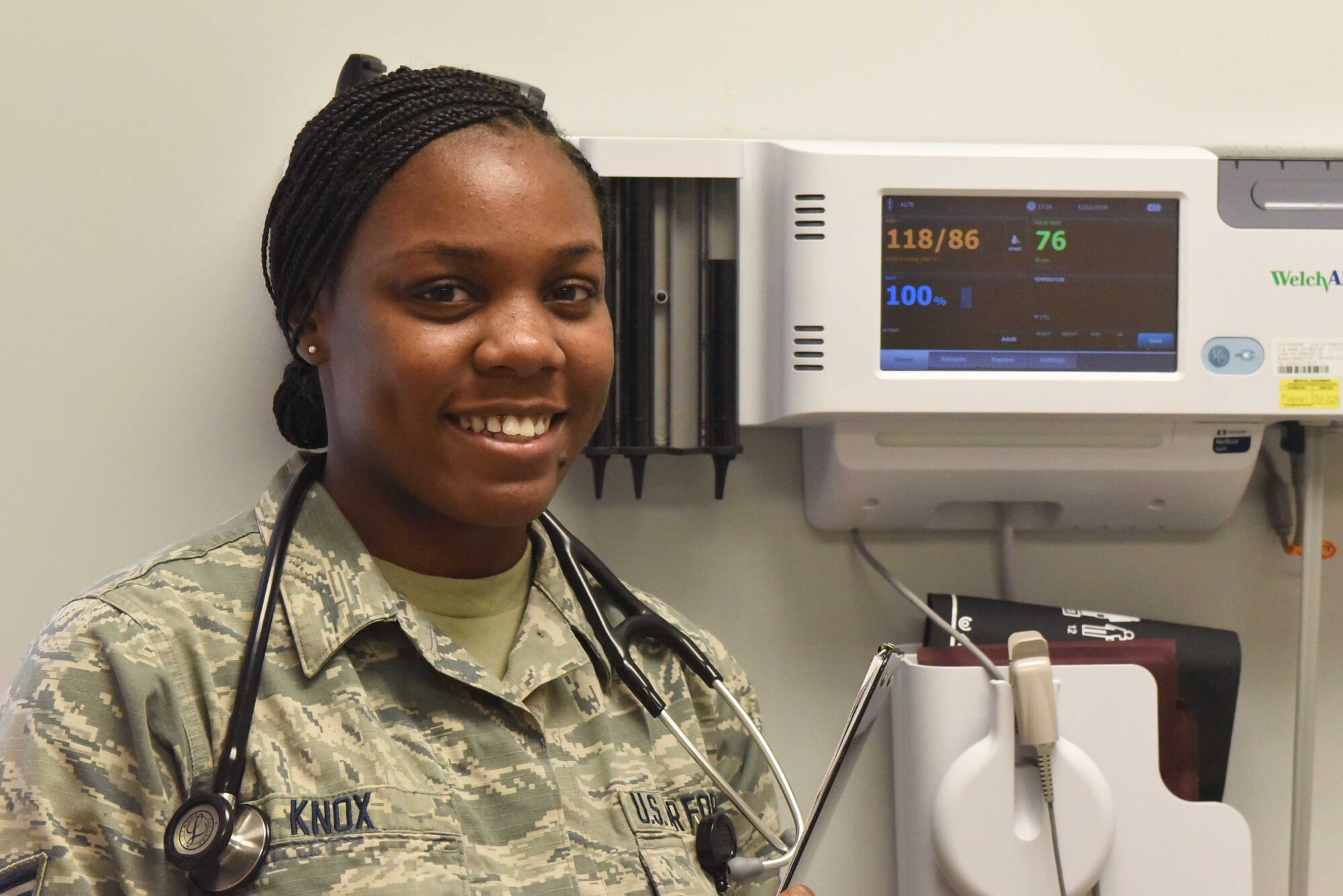 A medical Airman poses for a photo in a medical room.