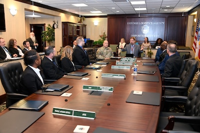New associates sit around a conference table with Director and Deputy
