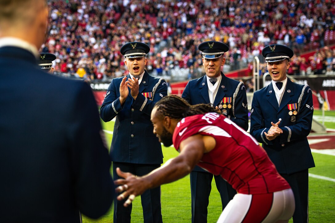 Members of the U.S. Air Force Drill Team and Color Guard cheer for Arizona Cardinals wide receiver Larry Fitzgerald to the field at the Salute to Service football game, Dec. 1, 2019, in Glendale, Ariz. In addition to the welcoming players, the USAF Drill Team performed during the halftime show. (U.S. Air Force photo by Tech. Sgt. Jensen Stidham)