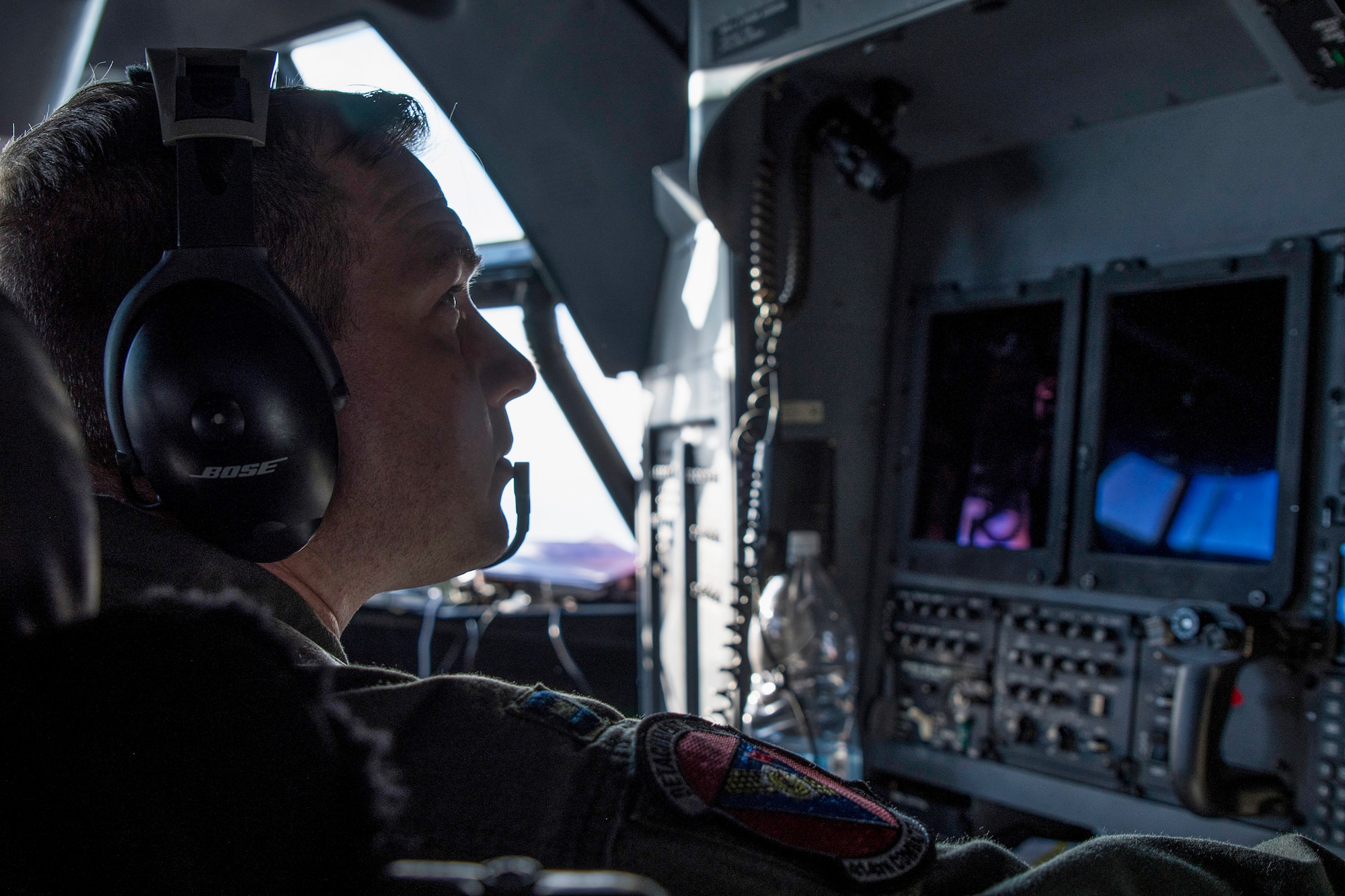 Photo of an Air Force aircraft systems officer monitoring the status of a military aircraft.