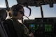 Photo of a pilot inside the cockpit of a military aircraft during a flight.