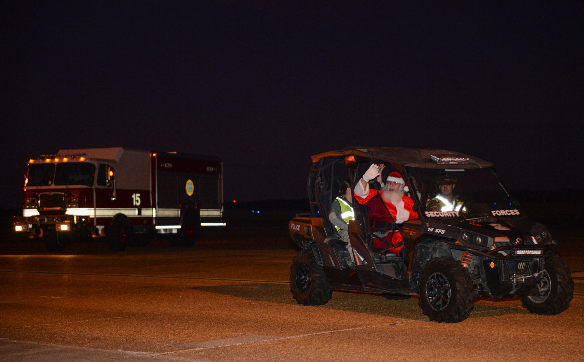 Santa waves to Airmen and their families before leading them on a walking parade Dec. 3, 2019, at Columbus Air Force Base, Miss. Santa Claus and Mrs. Claus arrived at the Columbus AFB flight line by riding in a T-1 Jayhawk. (U.S. Air Force photo by Airman Davis Donaldson)