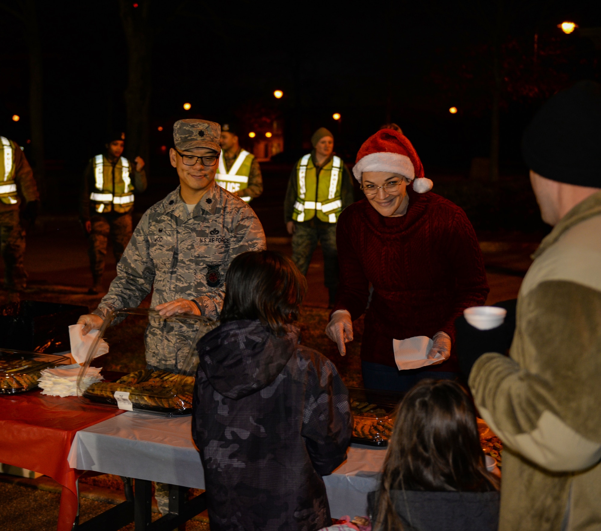 Team BLAZE members hand out cookies to families on Dec. 3, 2019, on Columbus Air Force Base, Miss. Team BLAZE kicked off the holiday season with Santa’s T-1A Jayhawk arrival followed by a tree lighting ceremony; hot chocolate and toys were also given out during the event. (U.S. Air Force photo by Airman Davis Donaldson)
