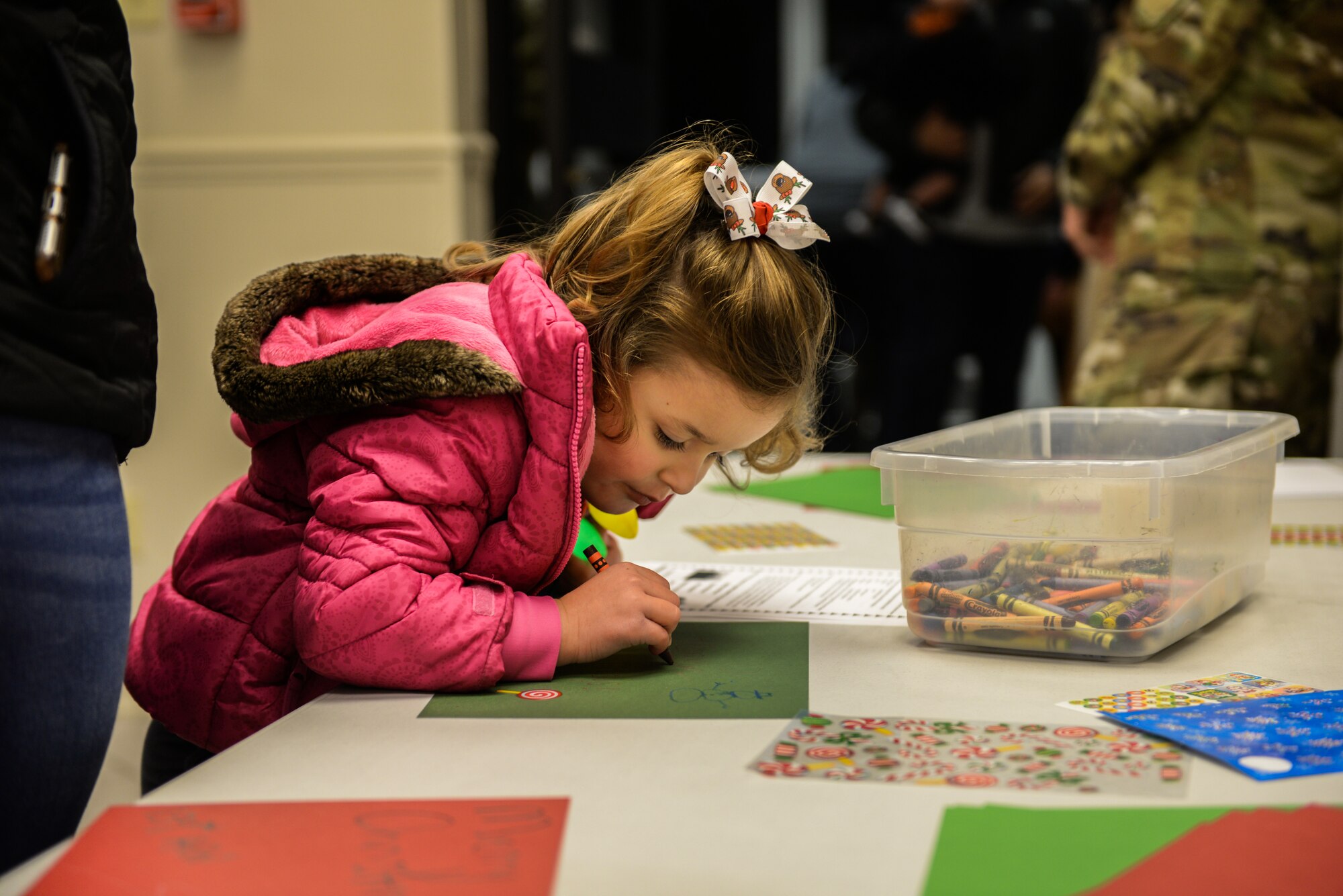 A child makes a Christmas card while waiting in line to take a photo with Santa Claus Dec. 3, 2019, at Columbus Air Force Base, Miss. The made Christmas cards will be sent to deployed Airmen during the holidays. (U.S. Air Force photo by Airman Davis Donaldson)