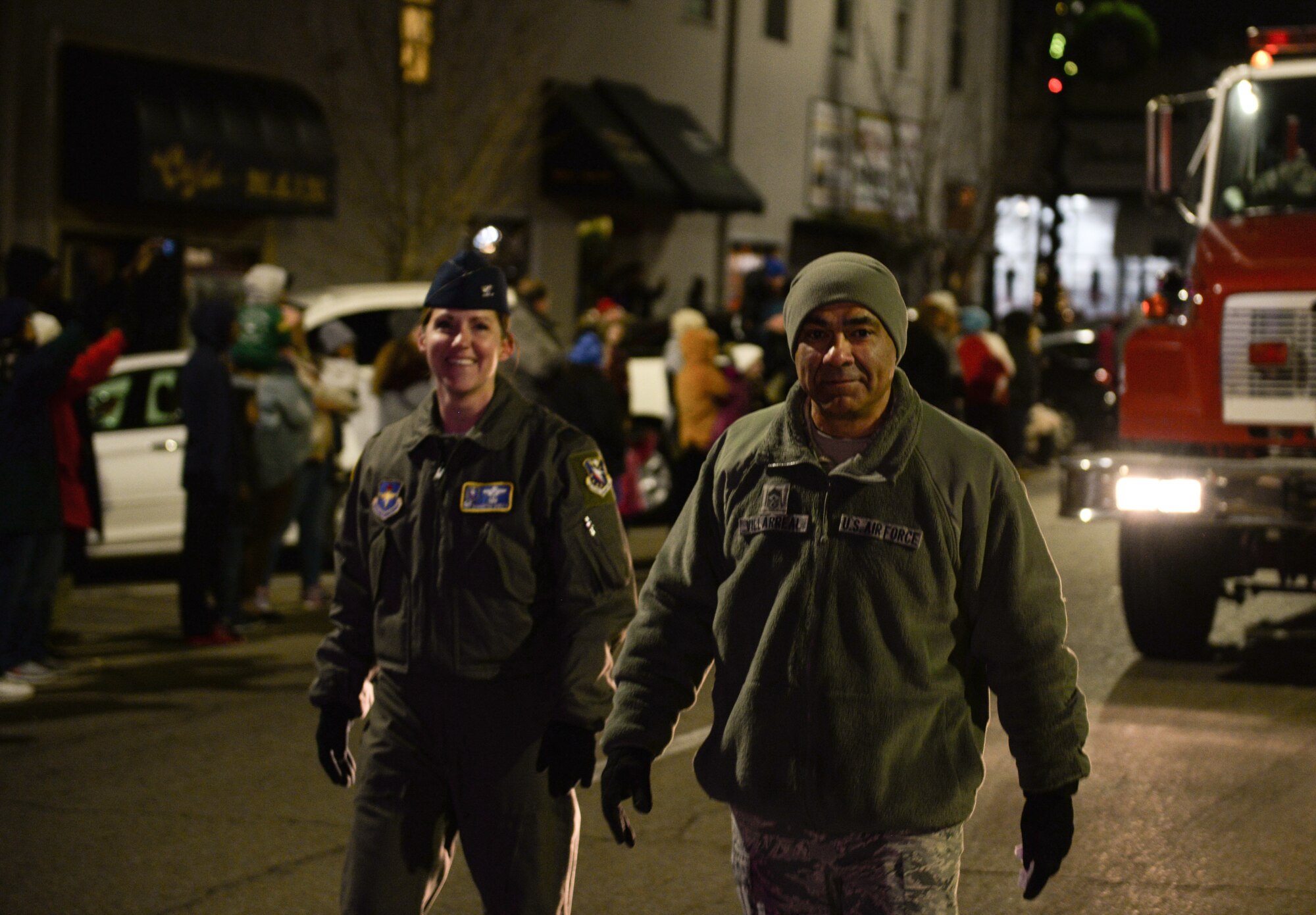 Col. Samantha Weeks, 14th Flying Training Wing commander, and Chief Master Sgt. Raul Villarreal Jr., 14th FTW command chief, walk in the Columbus Christmas Parade on Dec. 2, 2019, in Columbus, Miss. Members of the Columbus AFB Fire Department drove one of their trucks in the parade and were led by Weeks and Villarreal. (U.S. Air Force photo by Airman Davis Donaldson)