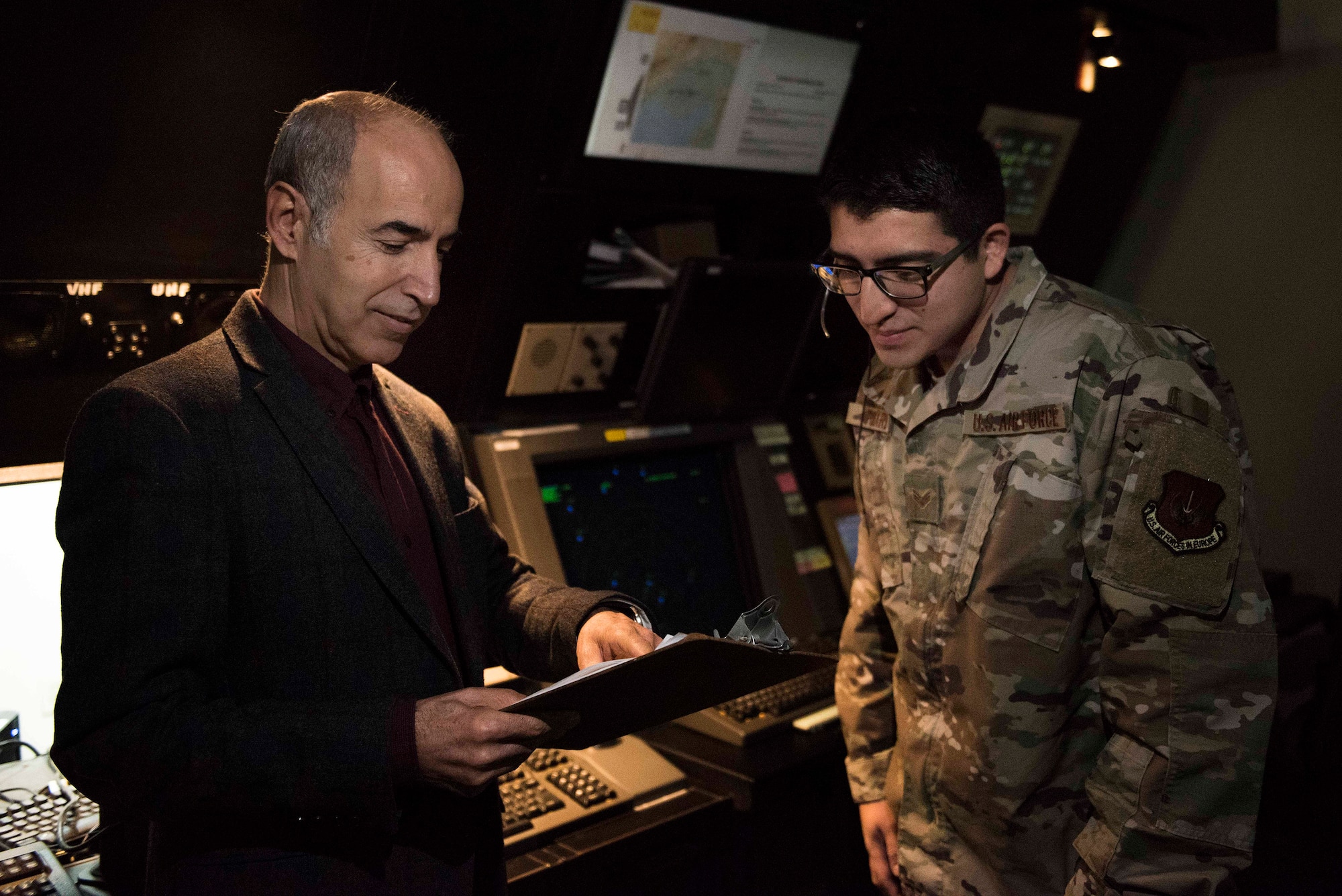 Sedat Arabaci, 39th Operations Support Squadron interpreter (left), discusses English-to-Turkish translation with U.S. Air Force Senior Airman Matthew Fouard, 39th OSS air traffic controller, Nov. 25, 2019, at Incirlik Air Base, Turkey. Turkish authorities share their airspace in Incirlik with the U.S. Air Force, making communication with the Turkish vital to the safety of aerospace operations. (U.S. Air Force photo by Staff Sgt. Joshua Magbanua)