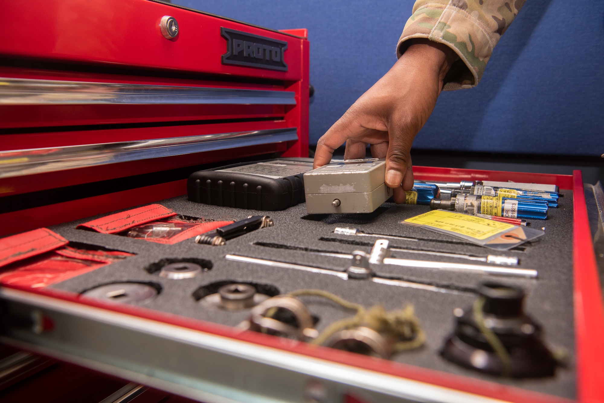 Tech. Sgt. Alexander Johnston, 100th Operations Support Squadron aircrew flight equipment lead trainer, retrieves a tool while repairing a piece of equipment at RAF Mildenhall, England, Dec. 3, 2019. Aircrew flight equipment Airmen inspect gear on a regular cycle to confirm it is free of defects. (U.S. Air Force photo by Airman 1st Class Joseph Barron)