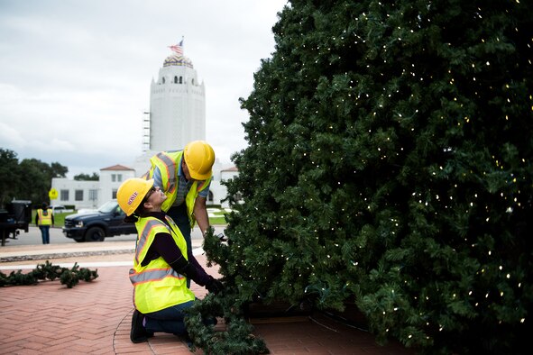 Rosa Padin, 502nd Civil Engineer Squadron secretary, helps decorate the base Christmas tree, Nov. 21, 2019, at Joint Base San Antonio-Randolph, Texas.