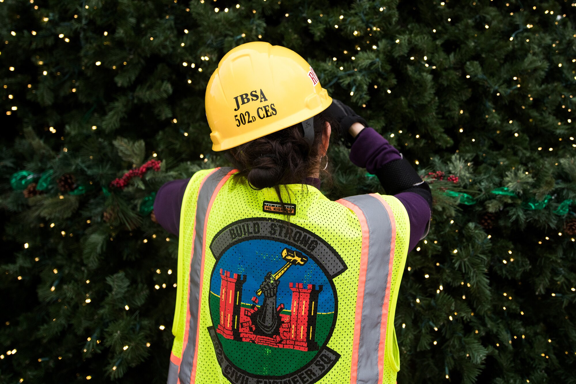 Rosa Padin, 502nd Civil Engineer Squadron secretary, helps decorate the base Christmas tree, Nov. 21, 2019, at Joint Base San Antonio-Randolph, Texas.