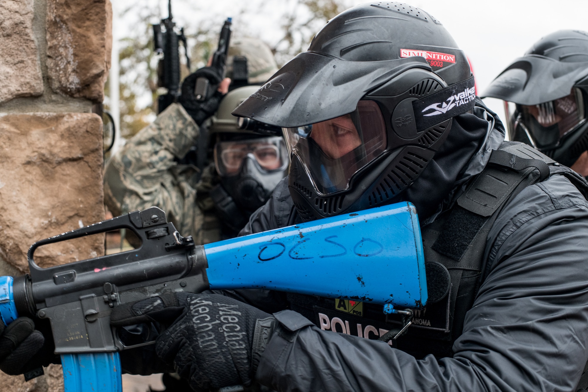 Ian Naylord, a SWAT team member of the Ardmore Police Department from Ardmore, Okla., checks around the corner of a building as he and a line of 137th Special Operations Wing Airmen and fellow Ardmore PD teammates prepareto tactically advance through an open area during an active shooter scenario for SWAT training conducted by the Oklahoma County Sheriff's Office in Oklahoma City on Nov. 7, 2019. (U.S. Air National Guard photo by Staff Sgt. Brigette Waltermire)