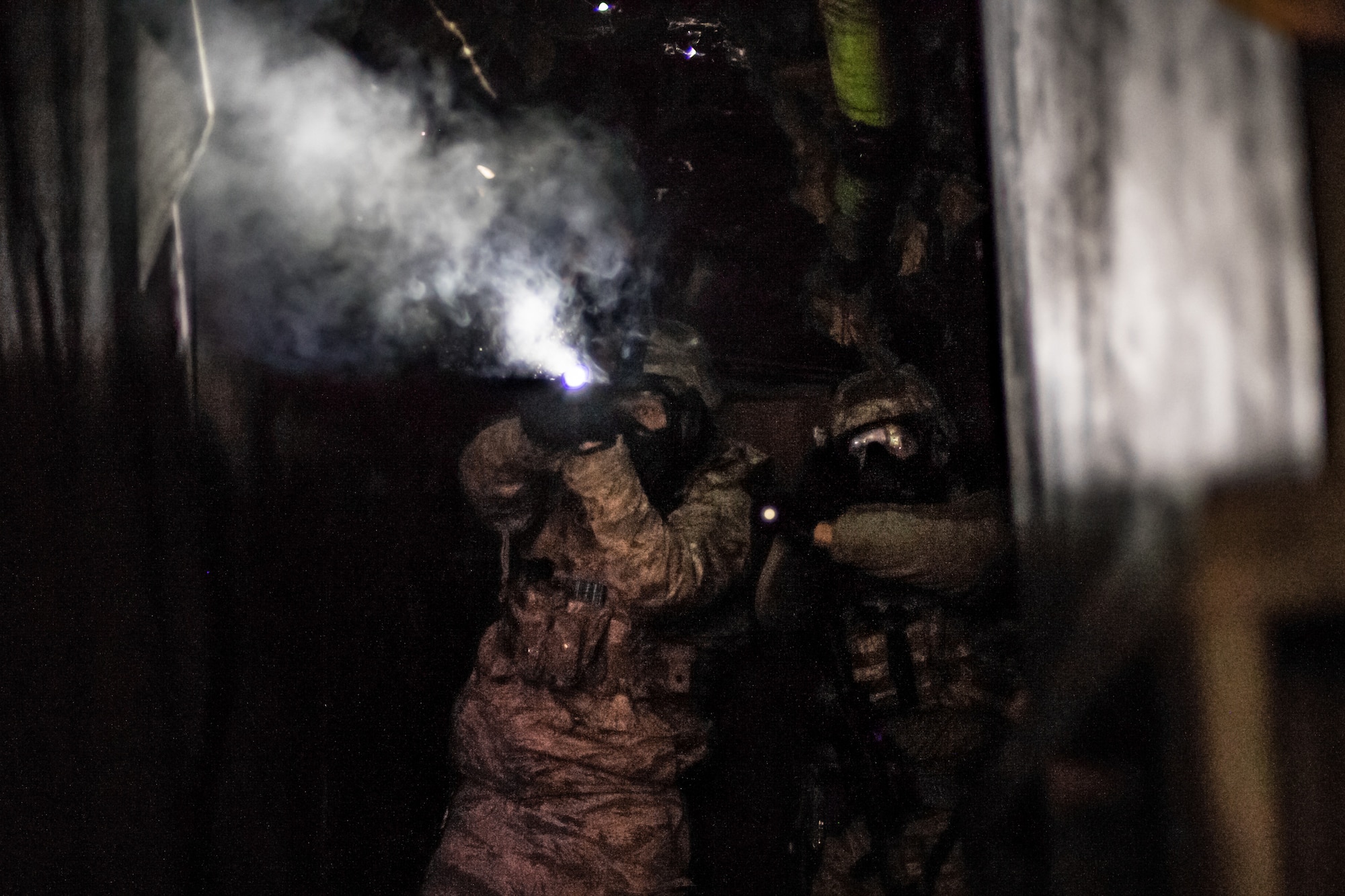 Senior Airman Michael Ragland, a security forces Airman with the 137th Special Operations Security Forces Squadron in Oklahoma City, returns fire as he and Airman 1st Class Harley Jones, also a security forces Airman with the 137th SOSFS, work to advance through a course during an active shooter training scenario for SWAT training conducted by the Oklahoma County Sheriff's Office in Oklahoma City on Nov. 5, 2019. (U.S. Air National Guard photo by Staff Sgt. Brigette Waltermire)