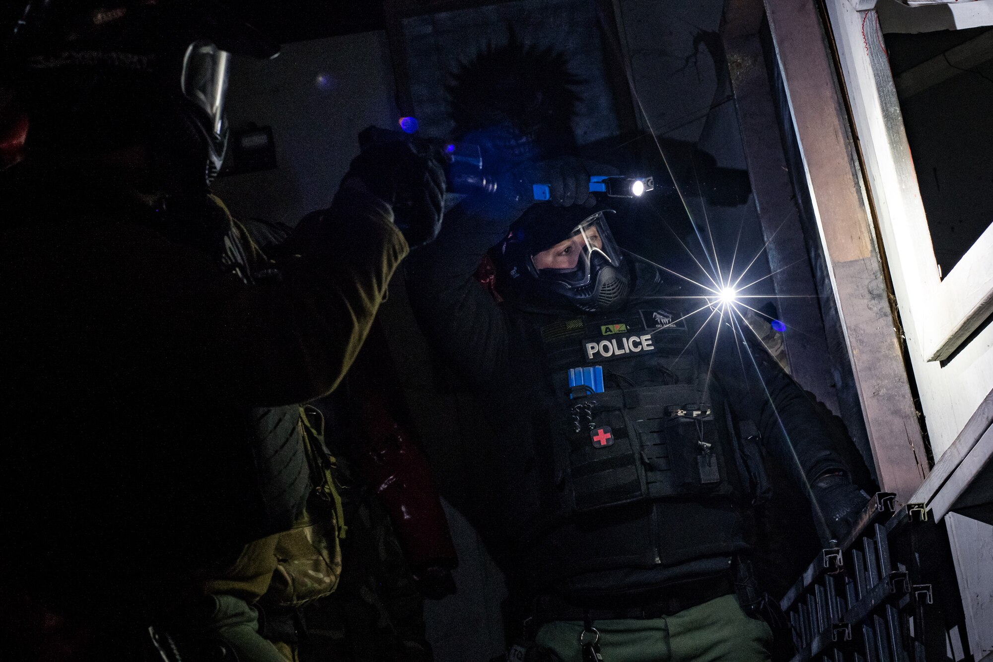 Ian Naylord, a SWAT team member with the Ardmore Police Department in Ardmore, Okla., works with Ardmore PD SWAT teammate Jared Johnson and a member of the 137th Special Operations Security Forces Squadron to tactically advance past a window during an active shooter scenario at SWAT training with the Oklahoma County Sheriff's Office in Oklahoma City on Nov. 7, 2019. (U.S. Air National Guard photo by Staff Sgt. Brigette Waltermire)