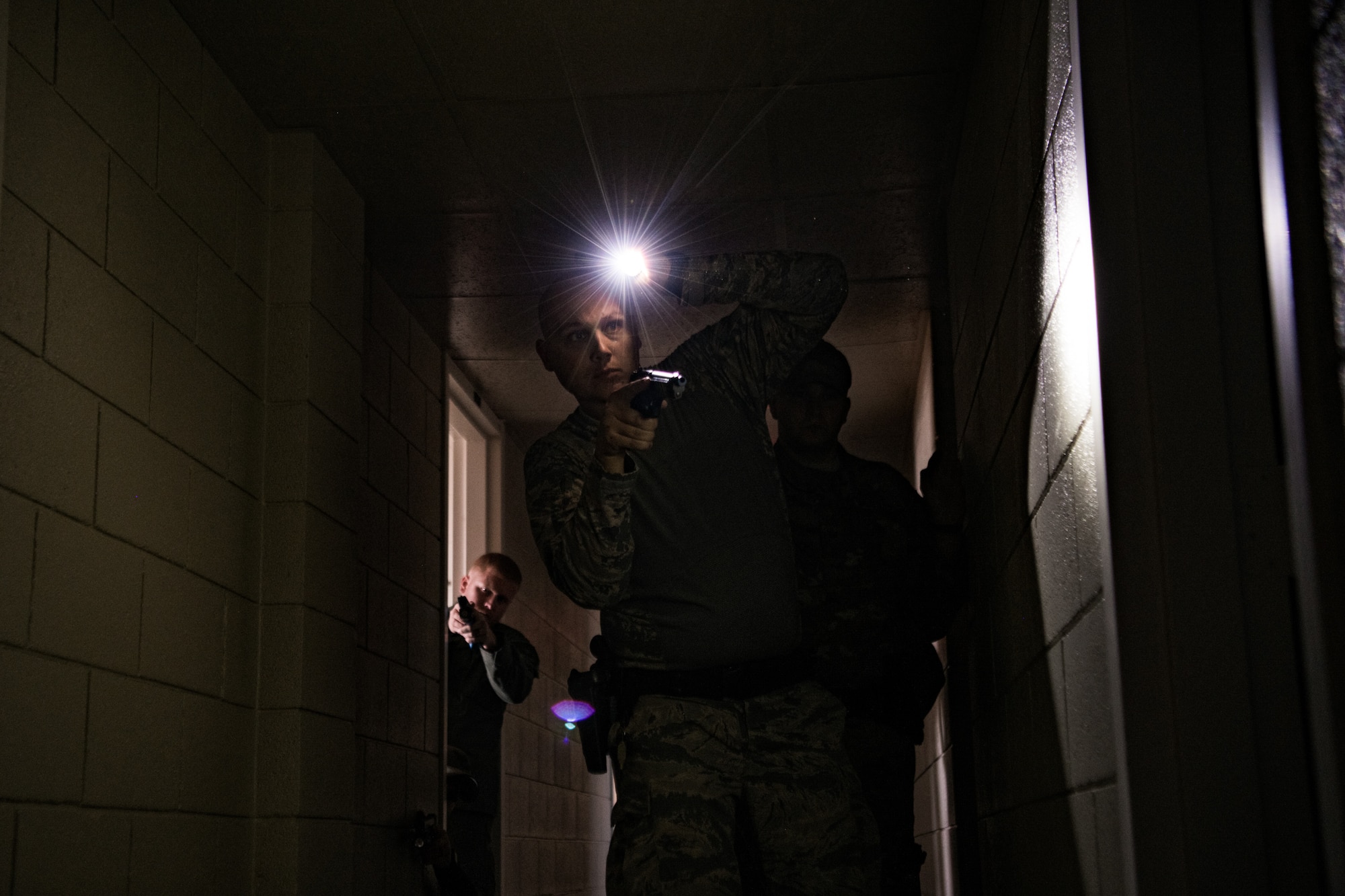 Four participants in SWAT training conducted by the Oklahoma County Sheriff's Office slowly work to clear a dormitory rooms in a hallway while looking for an instructor who is acting as an armed threat at Southern Nazarene University in Bethany, Okla., on Nov. 5, 2019. The two SWAT team members from Ardmore Police Department in Ardmore, Okla., secured the hallway as two members of the 137th Special Operations Security Forces Squadron approach a doorway. 



Nick Deniwellis (lower left), of Ardmore SWAT, crouches in front of Jared Johnson, also with Ardmore SWAT, as both hold the hallway for Staff Sgt. James Lunsford (right), with the 137th SOSFS, and Senior Airman Michael Ragland (center), with the 137th SOSFS, as they approach an unsecured doorway. This was Ragland’s first time in SWAT training, and he is working in a career field close to his heart: His grandfather was a highway patrolman in North Carolina for 8 years and was inspired to join this career field when he came into the military because of his grandfather. Additionally, Johnson was a Marine Corps infantryman before leaving the military and becoming a K-9 officer with the same department his dad retired from as a captain after 22 years of service in Ardmore. Both Ragland and Johnson bonded over that shared experience of joining a career field inspired by their family members who served in law enforcement. (U.S. Air National Guard photo by Staff Sgt. Brigette Waltermire)