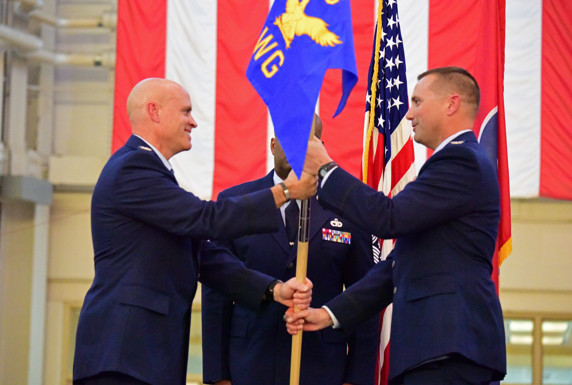 U.S. Air Force Col. Jason Glass, left, the assistant adjutant general of the Tennessee Air National Guard, passes the guide-on flag to Col. Todd Wiles, right, the incoming commander of the 118th Wing, at a wing change of command ceremony Nov. 3, 2019 at Berry Field Air National Guard Base, Nashville, Tennessee.