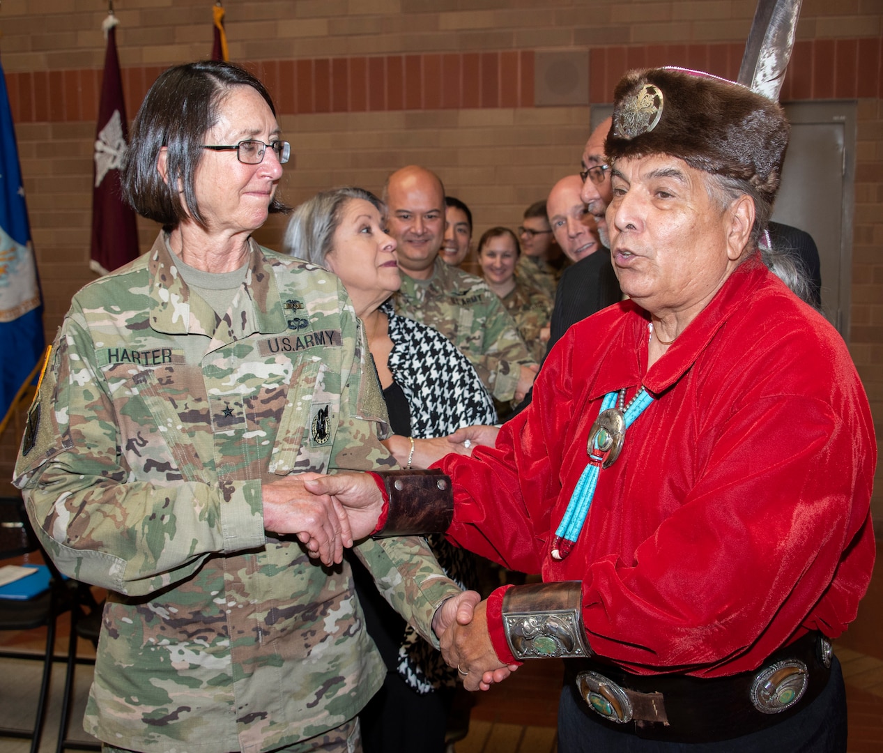 Erwin De Luna and Brooke Army Medical Center Commanding General Brig. Gen. Wendy Harter lead BAMC staff members in a traditional Native American dance during the National American Indian Heritage Month observance Nov. 26. De Luna is president of the board of directors for the United San Antonio Pow Wow Inc., and is of Taos Pueblo and Navajo ancestry.