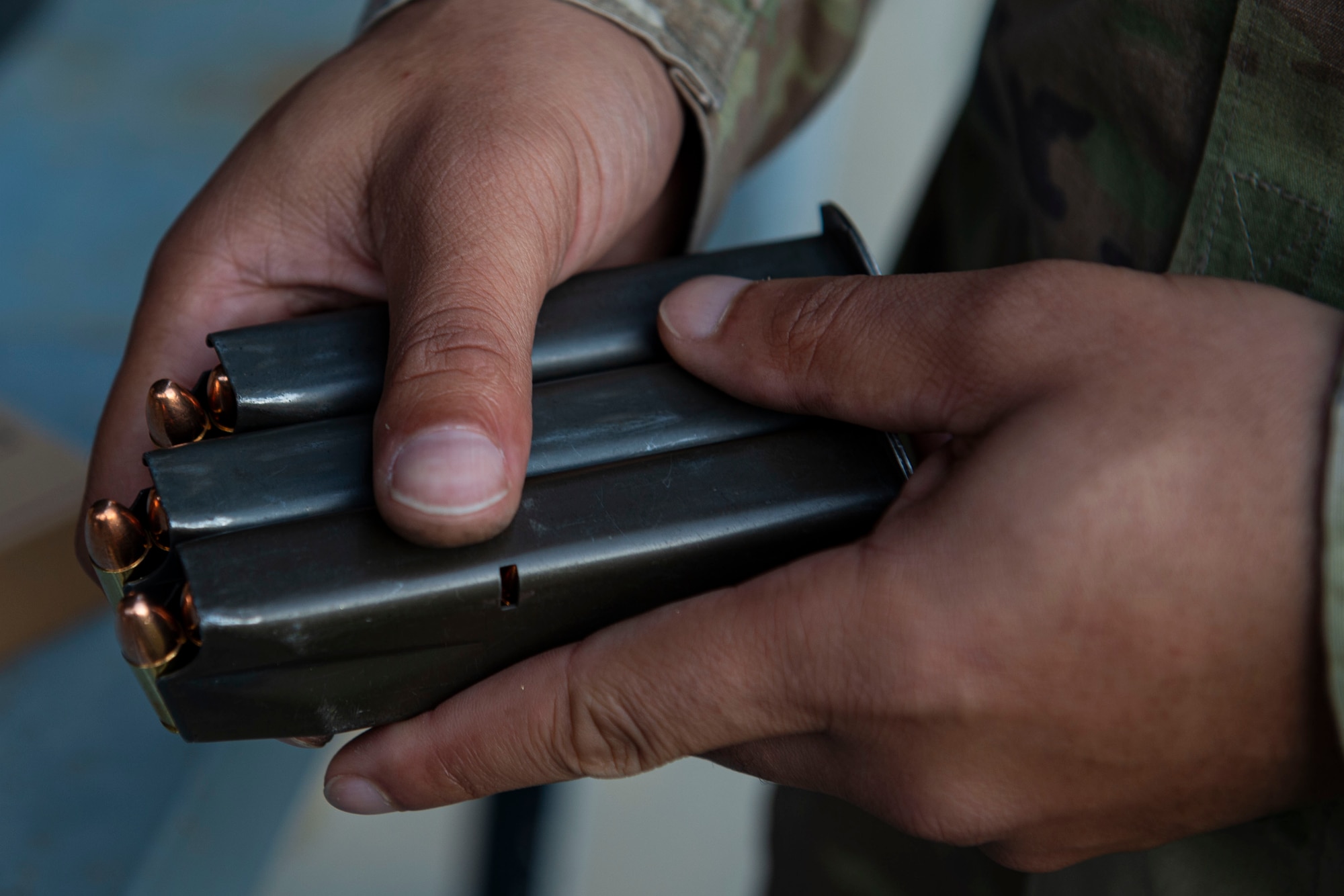 Photo of a combat arms instructor holding loaded magazines during an M4 and M9 Air Force Qualification Course