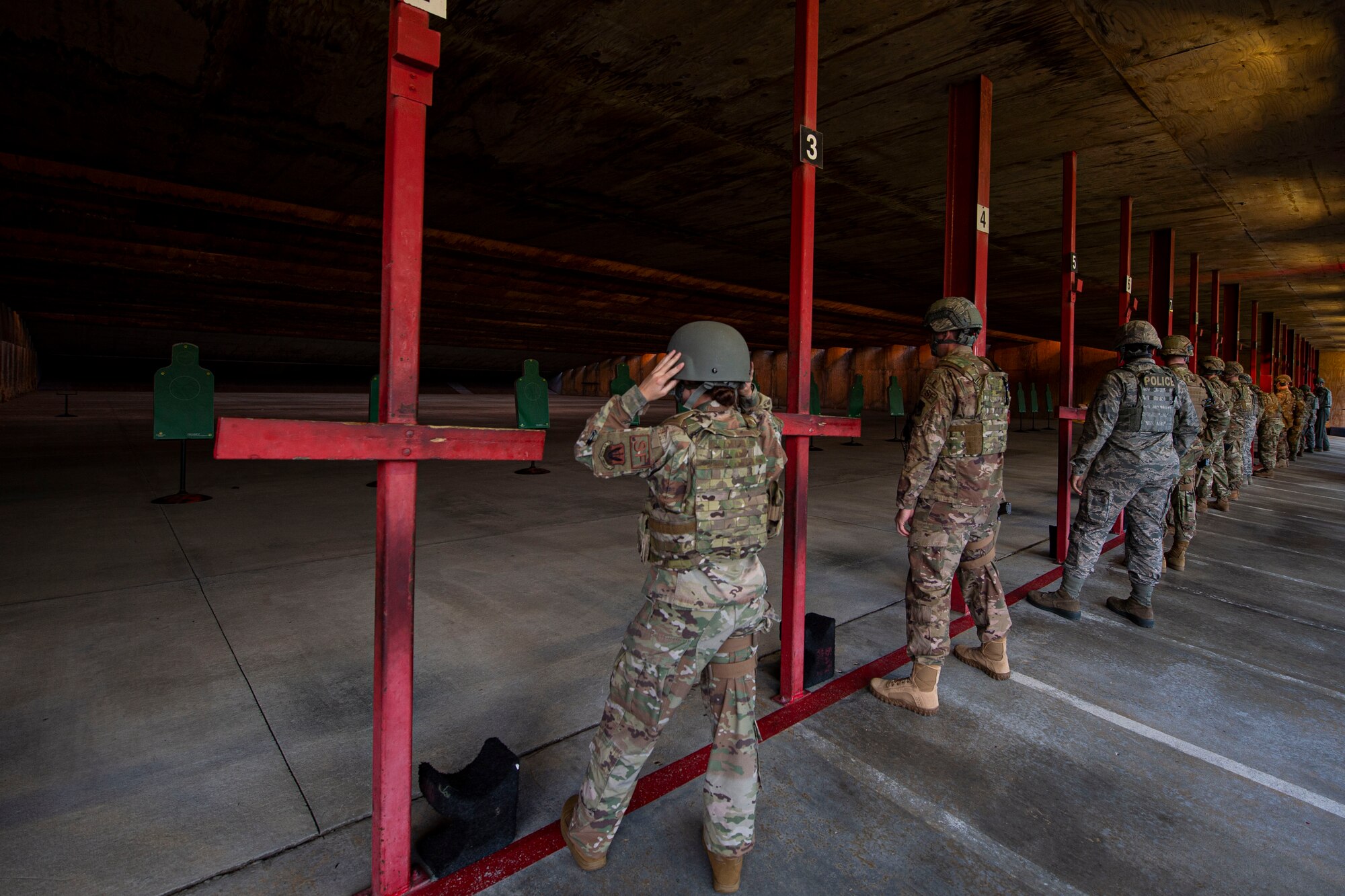 Photo of Airmen in an M4 and M9 Air Force Qualification Course preparing to fire weapons