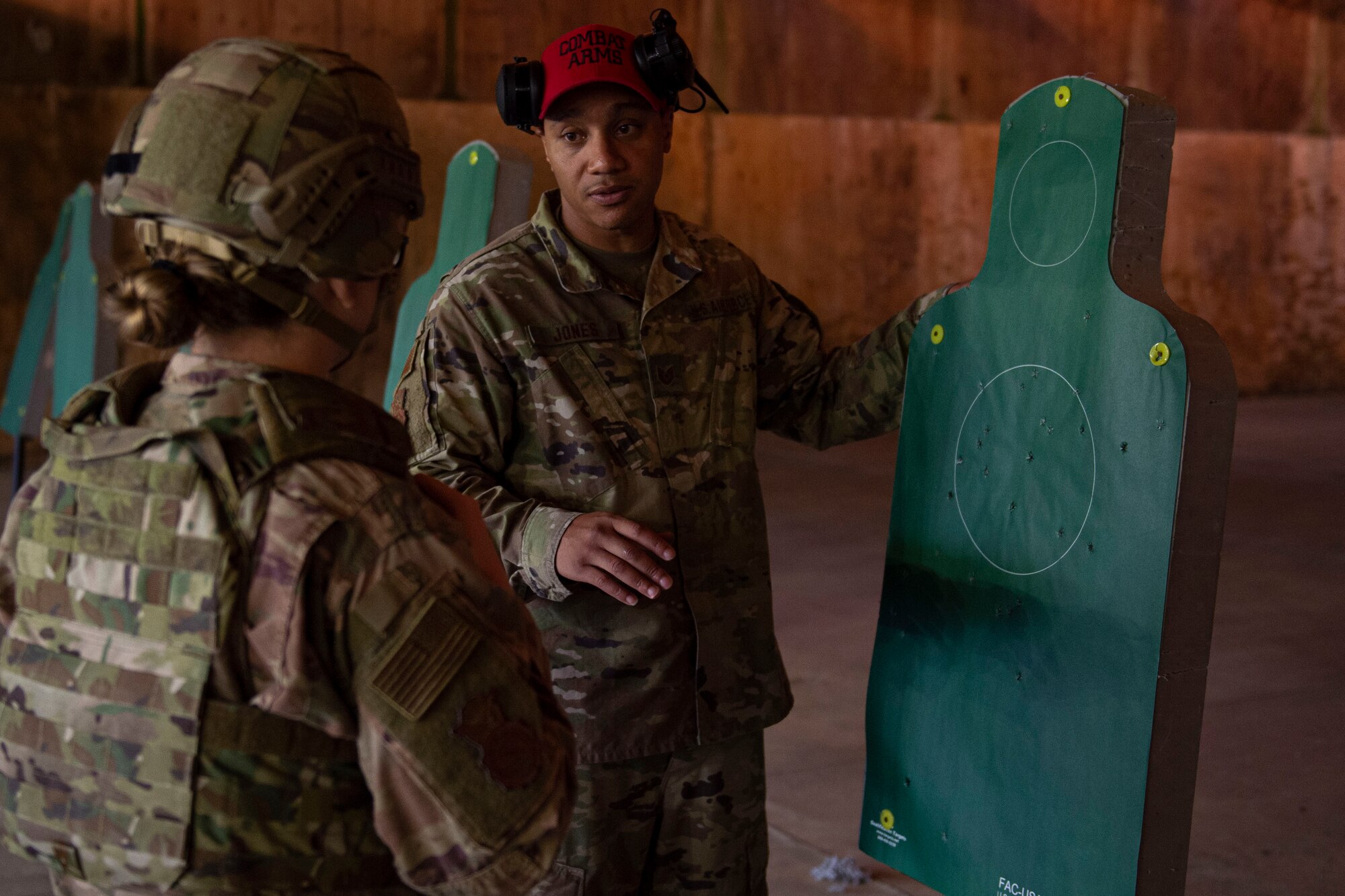 Photo of a combat arms instructor analyzing an Airman's target during an M4 and M9 Air Force Qualification Course