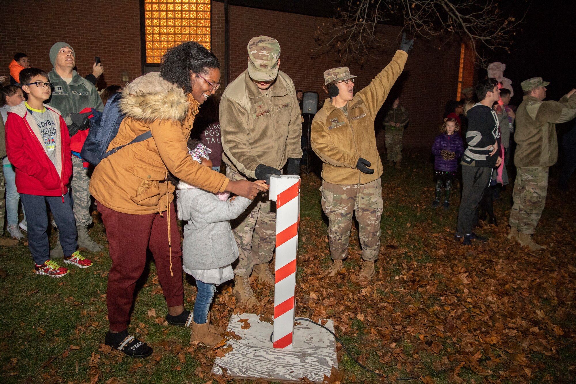 Col. Joel Safranek, 436th Airlift Wing commander, Kirdesa Anderson, wife of currently deployed Staff. Sgt. Anthony Anderson, and their daughter light the base Christmas tree during the tree lighting ceremony Dec. 3, 2019, at Chapel 2 on Dover Air Force Base, Del. (U.S. Air Force photo by Senior Airman Christopher Quail)