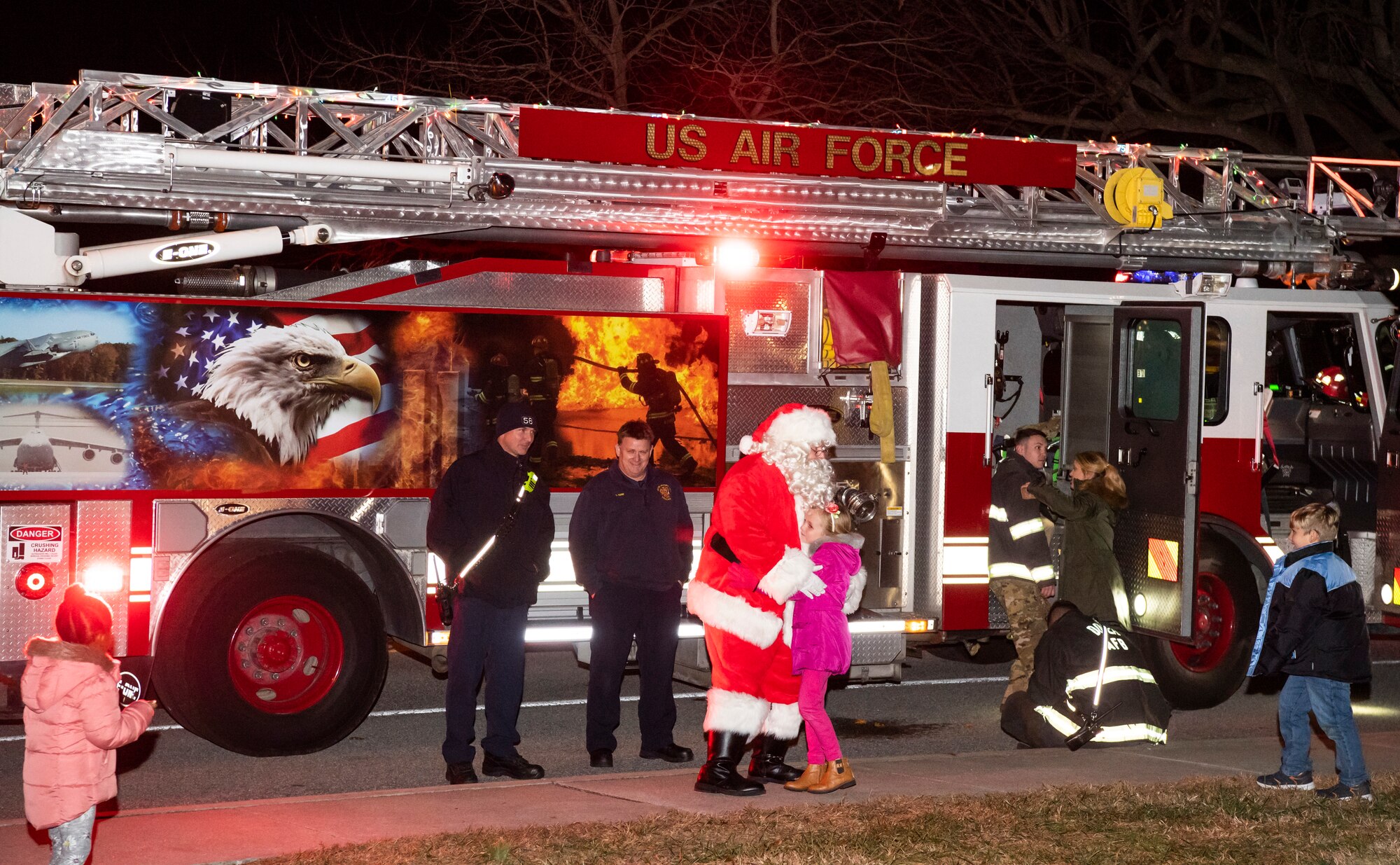 Children hug Santa during his visit to Chapel 2, Dec. 3, 2019, at Dover Air Force Base, Del. Santa arrived on one of Team Dover's fire trucks. (U.S. Air Force photo by Senior Airman Christopher Quail)