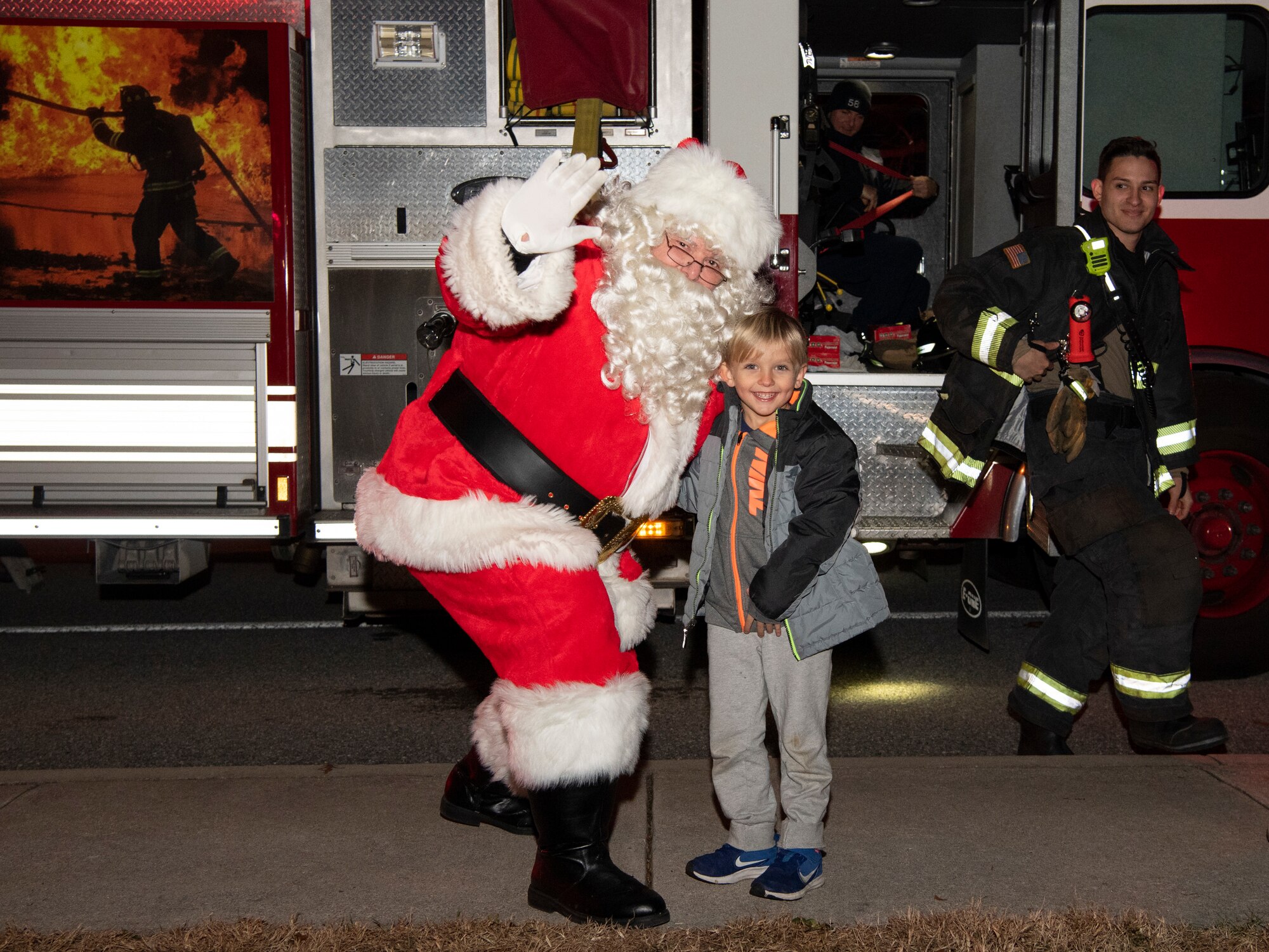 A child poses with Santa during his visit Dec. 3, 2019, at Dover Air Force Base, Del. Santa arrived on one of Team Dover's fire trucks. (U.S. Air Force photo by Senior Airman Christopher Quail)