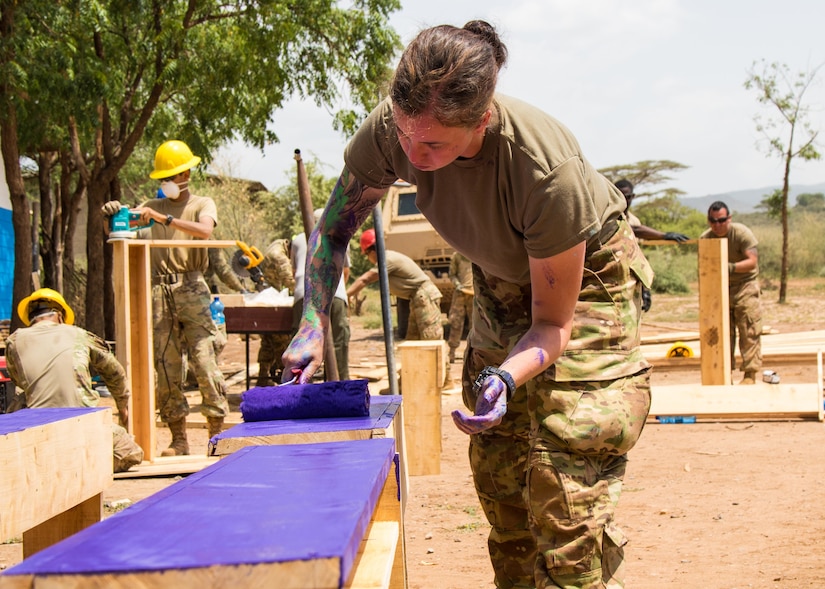 A soldier paints a desktop purple.