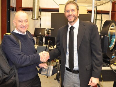 IMAGE: DAHLGREN, Va. (Dec. 3, 2019) - British Royal Navy Rear Adm. Hugh Beard shakes hands with Dr. Chris Lloyd, High Energy Laser Lethality lead at Naval Surface Warfare Center Dahlgren Division (NSWCDD), during a presentation held after a live test demonstration. Lloyd presented Beard – the U.K. assistant chief of the Naval Staff (Capability) – with a steel metal sample irradiated and penetrated in the command’s High Energy Laser Lethality laboratory. NSWCDD subject matter experts briefed Beard and his delegation of Royal Navy officers on programs and capabilities that included NSWCDD directed energy weapons such as the high energy laser, electromagnetic railgun, and hyper-velocity projectile in addition to high power radio frequency capabilities and the weaponization of unmanned systems. The assistant chief of the Naval Staff (Capability) is responsible for planning and delivering the larger part of the Royal Navy’s future maritime effectiveness. (U.S. Navy photo/Released)