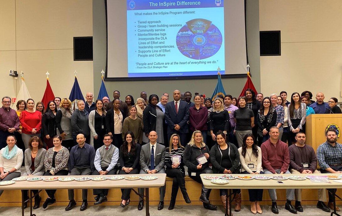 Employees from DLA Troop Support’s Industrial Hardware Success and Partnership in Reaching Excellence mentoring program pose for a photo after assembling morale and resiliency bags for deployed warfighters December 3, 2019, in Philadelphia.