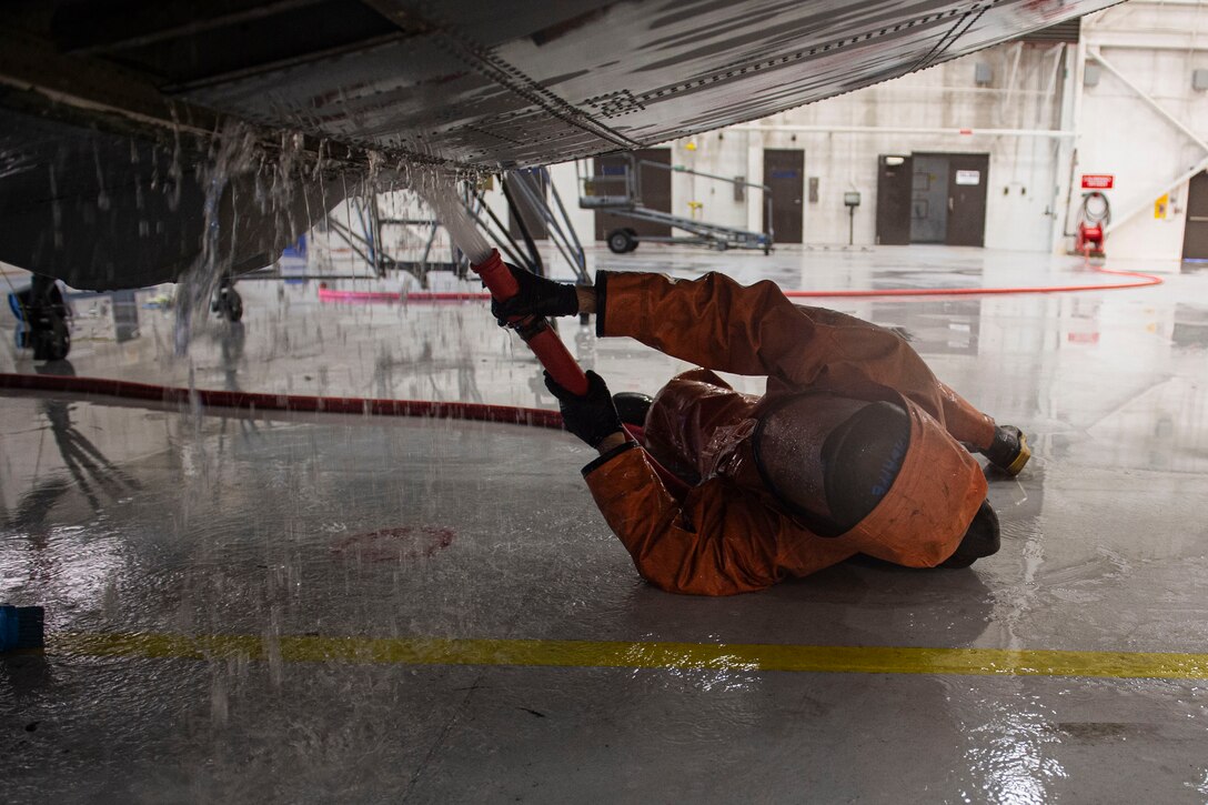 Photo of an Airman spraying the underside of an HC-130J Combat King II
