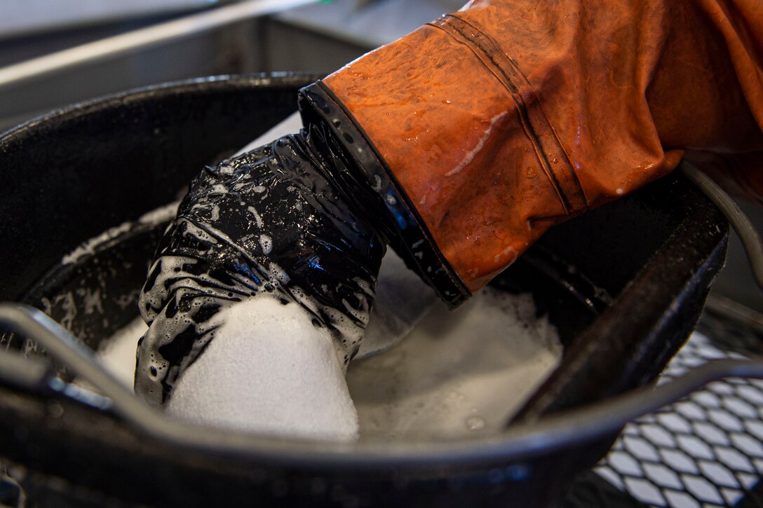 Photo of an Airman dipping a wash pad in soap during an HC-130J Combat King II