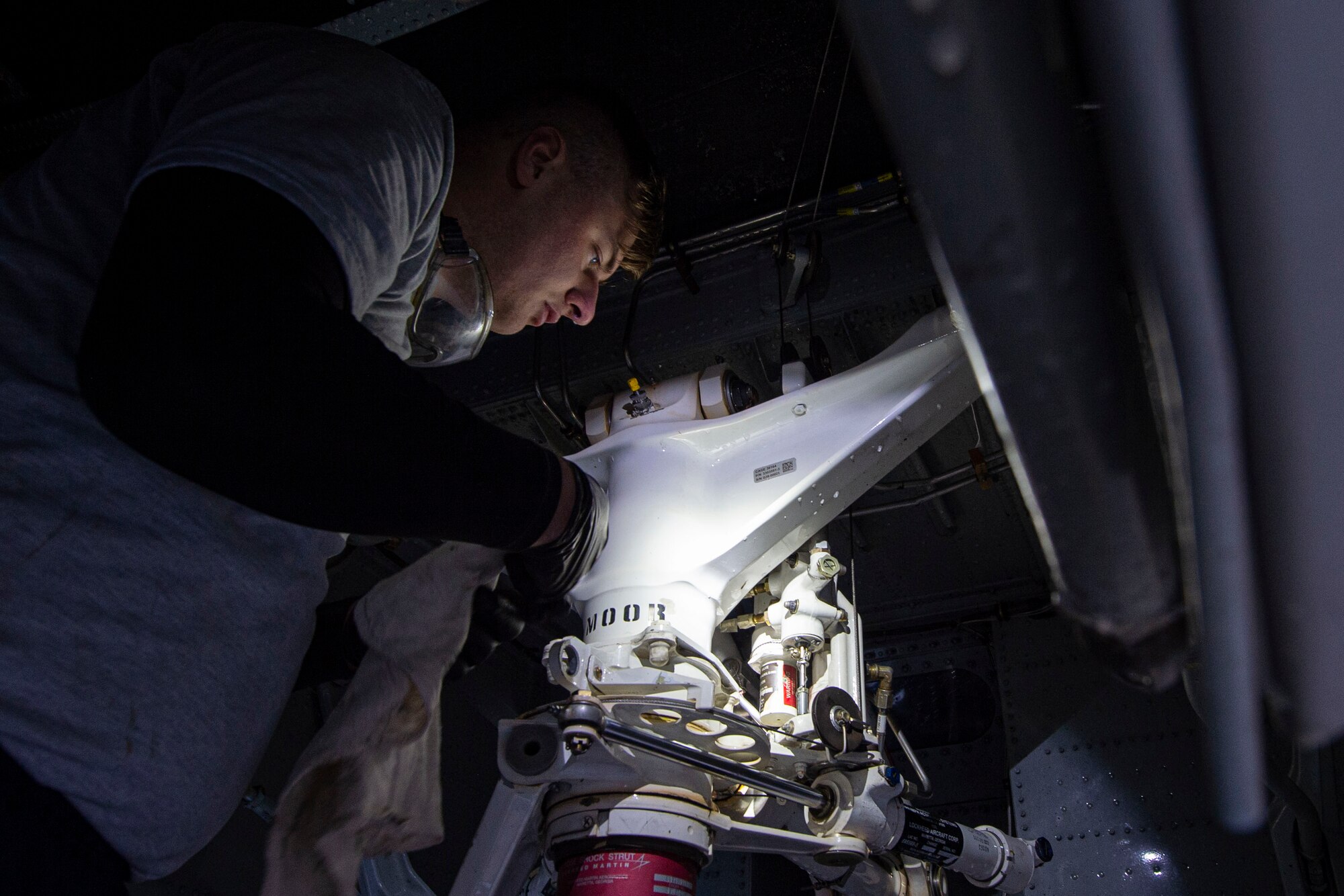 Photo of an Airman cleaning the nose gear of an HC-130J Combat King II