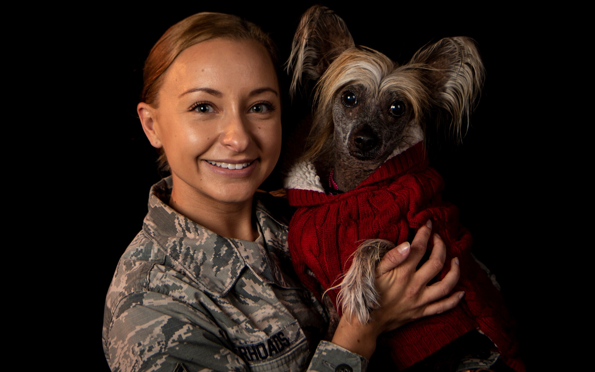 An Airman holds a therapy dog.